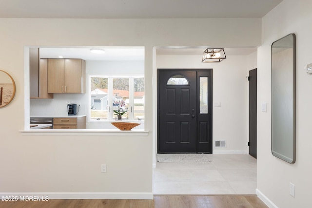 entrance foyer with wood finished floors, visible vents, and baseboards