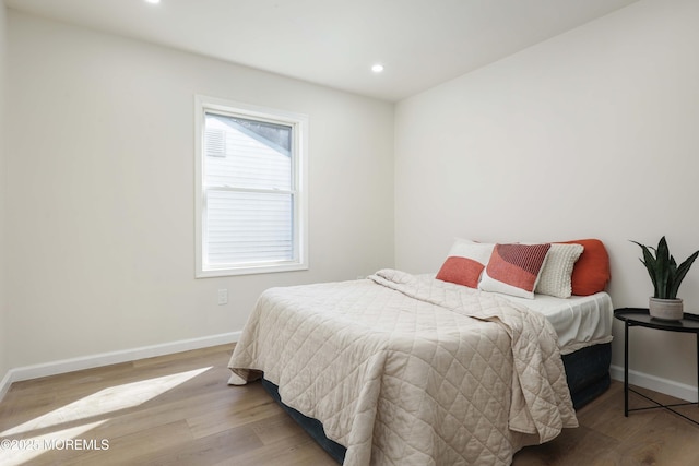 bedroom with recessed lighting, wood finished floors, and baseboards