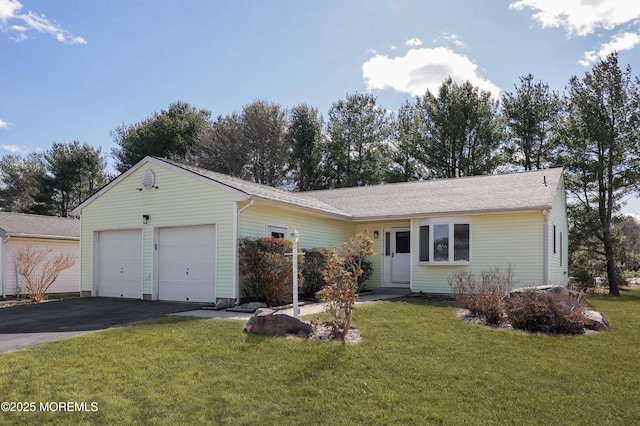 single story home featuring driveway, a front yard, and a garage