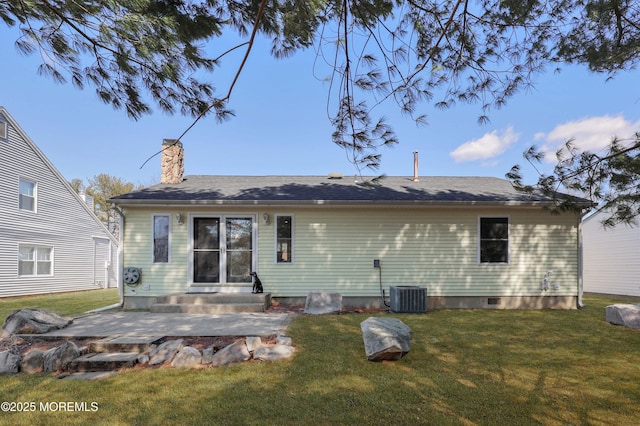 rear view of property featuring a patio area, entry steps, a chimney, and a yard