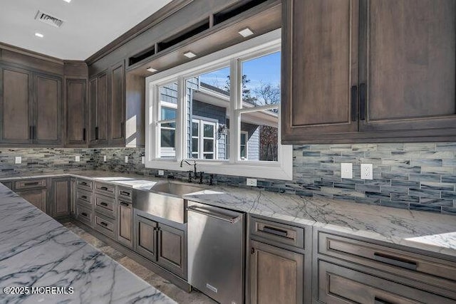 kitchen featuring light stone countertops, visible vents, a sink, dishwasher, and backsplash