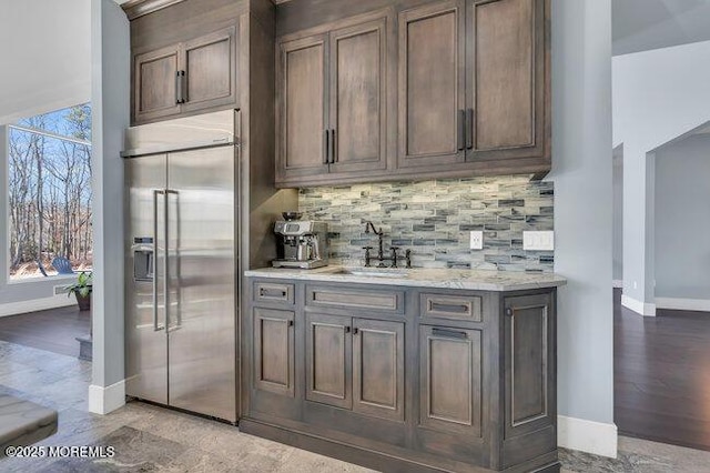 bar with a healthy amount of sunlight, tasteful backsplash, and built in fridge