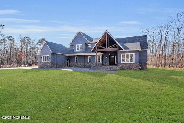 view of front of home with stone siding and a front lawn