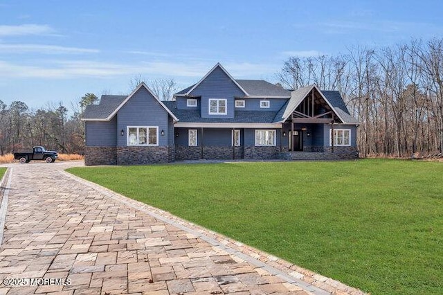 craftsman-style home featuring stone siding and a front yard