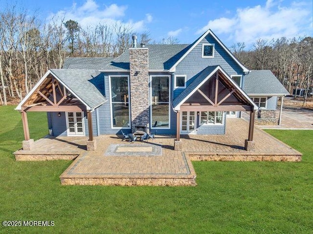 back of property with french doors, a lawn, and a patio area