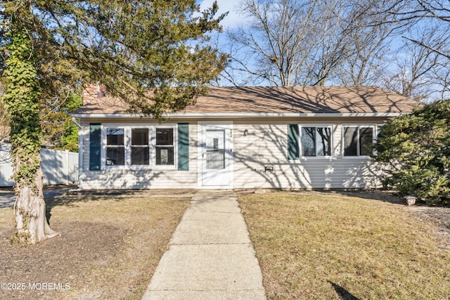 view of front facade featuring a front lawn and fence