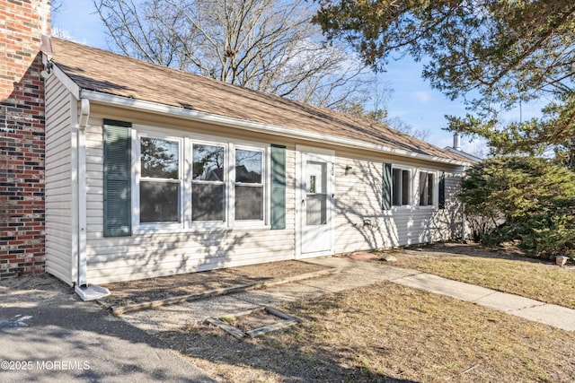 view of front of house featuring a shingled roof and a chimney