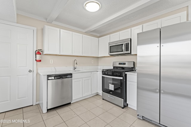 kitchen featuring a sink, appliances with stainless steel finishes, white cabinets, and light countertops