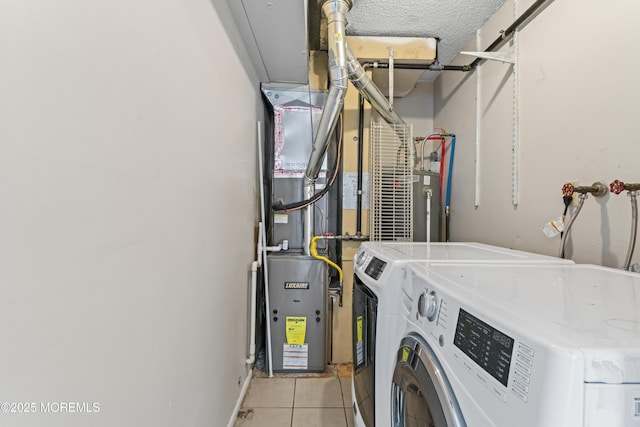 clothes washing area with laundry area, light tile patterned flooring, a textured ceiling, gas water heater, and washer and clothes dryer