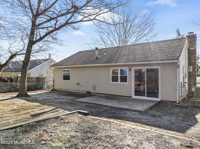 back of property with central AC, fence, a shingled roof, a chimney, and a patio area