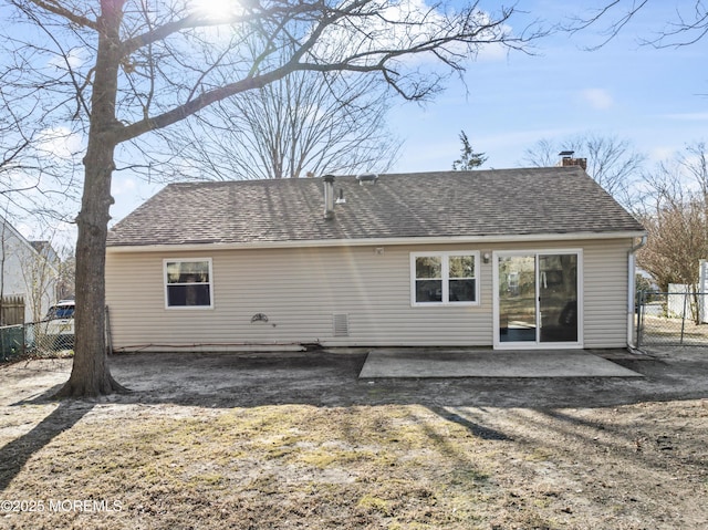 back of property with a patio, roof with shingles, a chimney, and fence