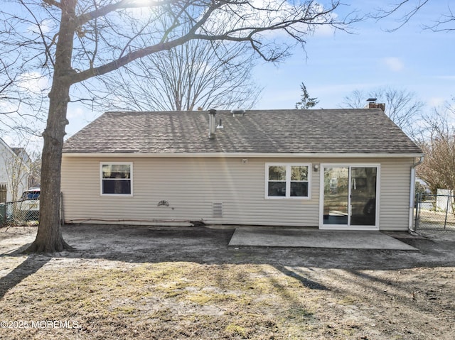 rear view of property with a chimney, roof with shingles, a patio, and fence