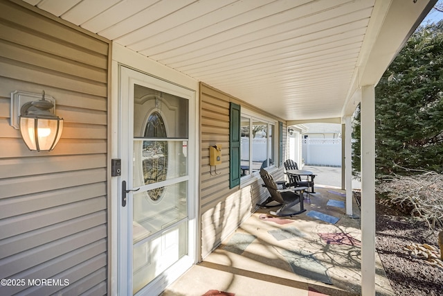 view of patio / terrace featuring fence and covered porch