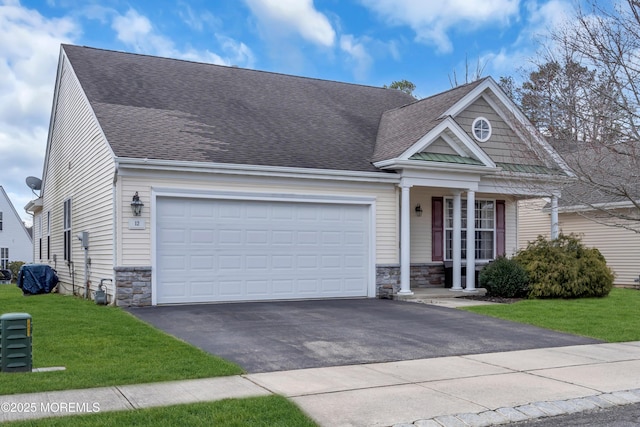 view of front of house with a front yard, driveway, roof with shingles, an attached garage, and stone siding