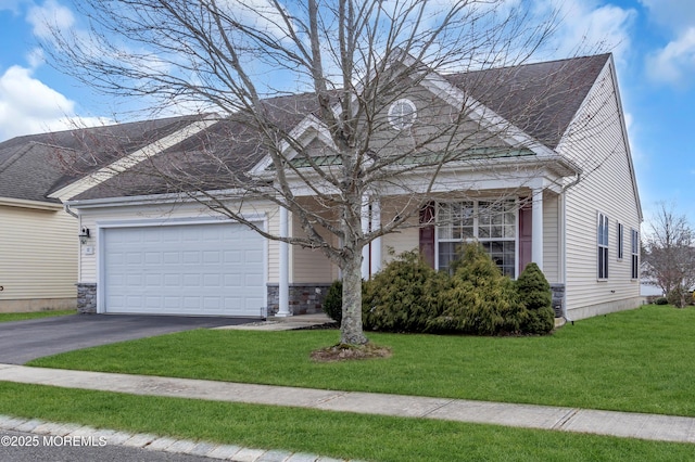 view of front facade with stone siding, driveway, a front yard, and a garage