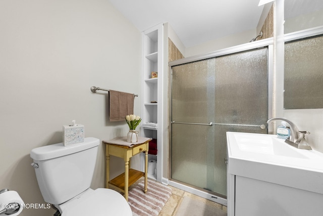 bathroom featuring vanity, toilet, and a shower stall