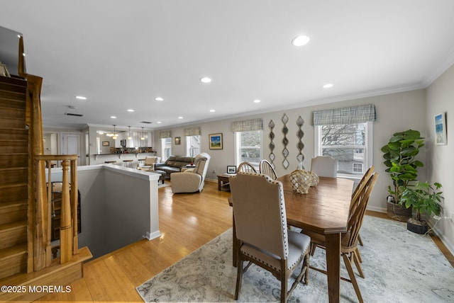 dining area with crown molding, light wood-style flooring, recessed lighting, and baseboards