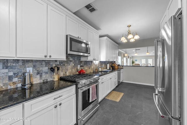 kitchen with visible vents, backsplash, stainless steel appliances, an inviting chandelier, and white cabinets