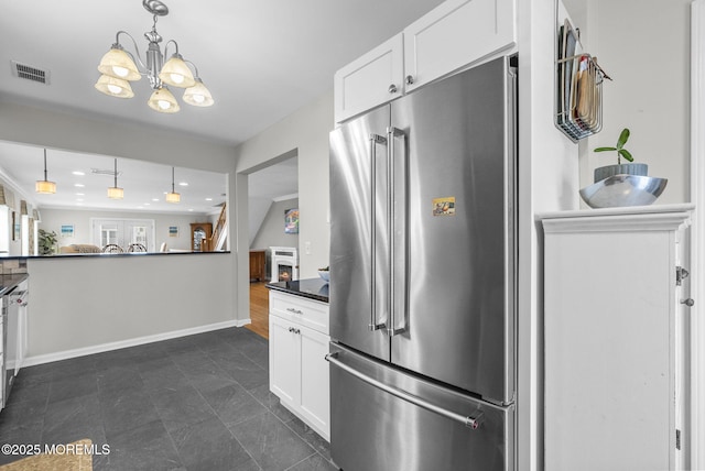 kitchen with decorative light fixtures, visible vents, high end fridge, and white cabinets