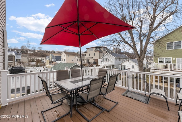 deck featuring outdoor dining space and a residential view