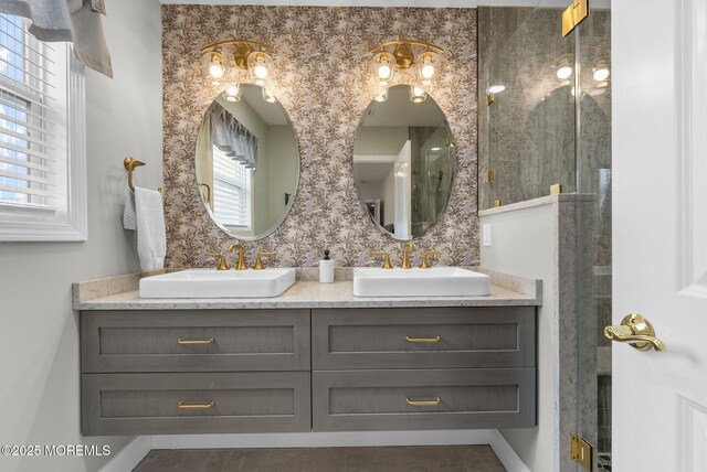 full bathroom featuring a sink, a shower with door, and double vanity