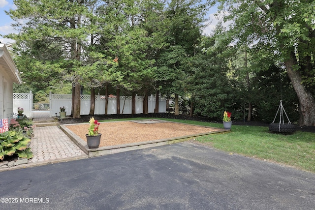 exterior space featuring a gate, a front lawn, and fence