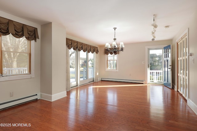 interior space with wood finished floors, baseboards, a baseboard radiator, a baseboard heating unit, and a chandelier