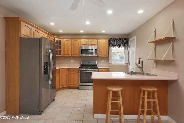 kitchen featuring a sink, open shelves, stainless steel appliances, a peninsula, and a breakfast bar area