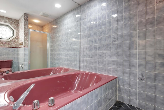 bathroom featuring visible vents, tile walls, a stall shower, and a bath