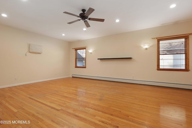 empty room with baseboards, light wood-type flooring, baseboard heating, recessed lighting, and a ceiling fan