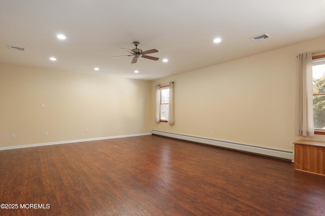 empty room with recessed lighting, a baseboard radiator, visible vents, and dark wood finished floors