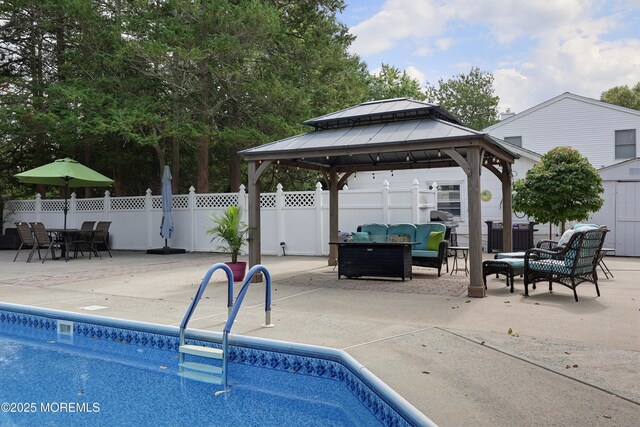 view of pool with an outdoor living space, a fenced in pool, fence, a gazebo, and a patio area