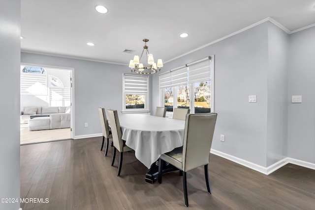 dining room with baseboards, visible vents, dark wood finished floors, ornamental molding, and a chandelier