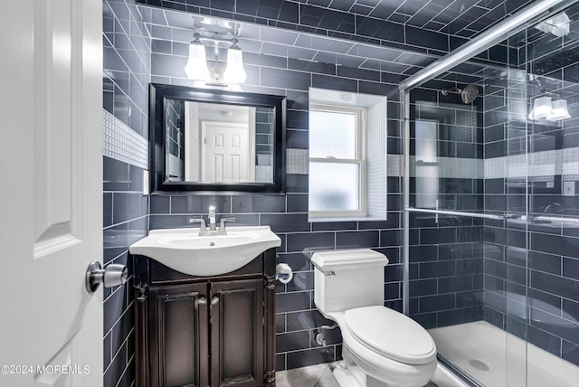 full bath with tile walls, a shower stall, vanity, and toilet