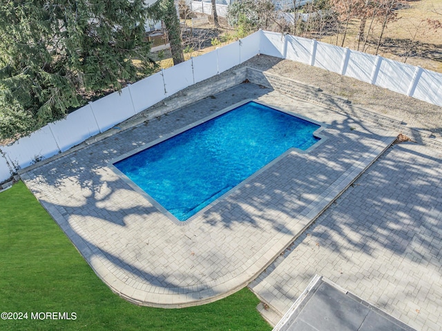 view of swimming pool featuring a fenced in pool, a patio, a lawn, and a fenced backyard