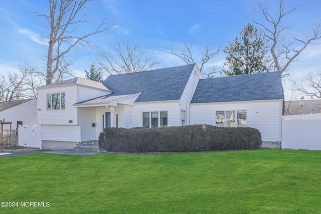 view of front of property featuring fence, driveway, a shingled roof, a front lawn, and a garage