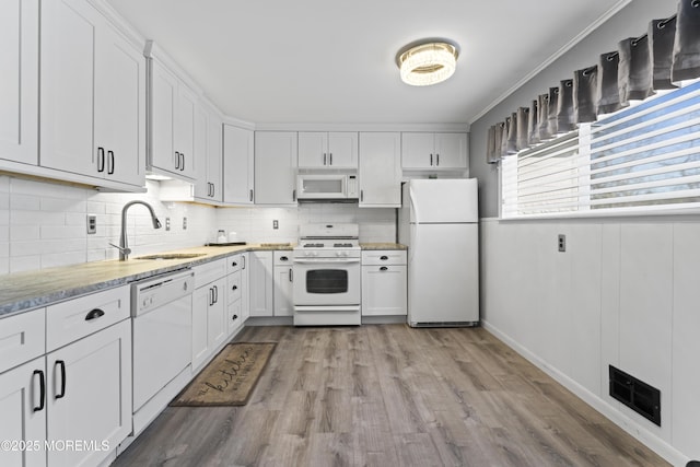 kitchen with visible vents, a sink, tasteful backsplash, white appliances, and white cabinets