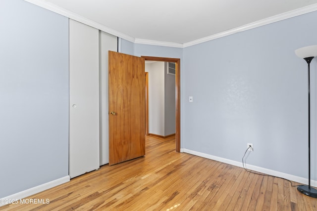 unfurnished room featuring crown molding, baseboards, and light wood-type flooring