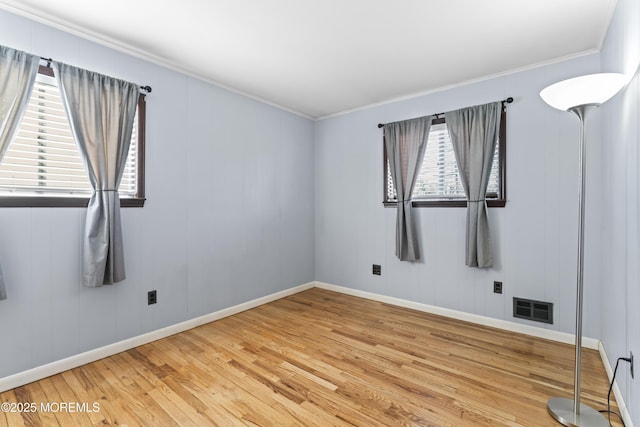 unfurnished room featuring crown molding, baseboards, visible vents, and light wood finished floors