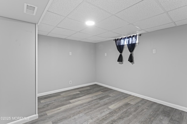 basement featuring visible vents, baseboards, and wood finished floors