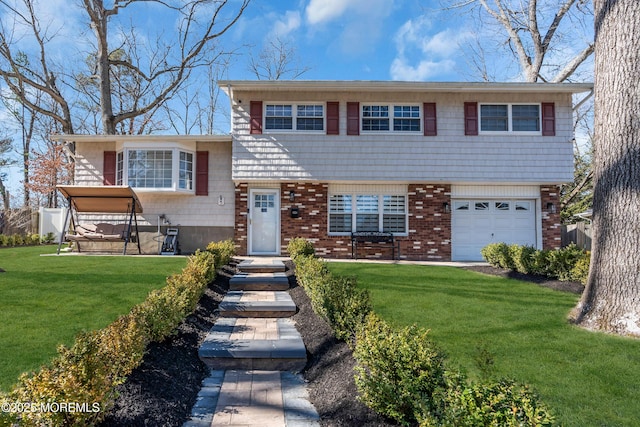 tri-level home with a front yard, an attached garage, fence, and brick siding