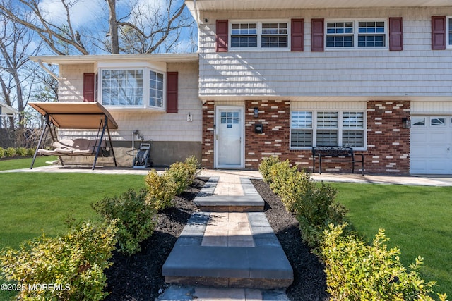 view of front of house with a garage, brick siding, and a front yard