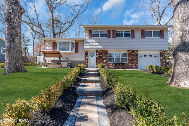 tri-level home with a garage, brick siding, and a front lawn