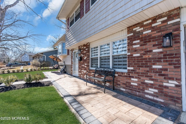 exterior space with brick siding and a lawn