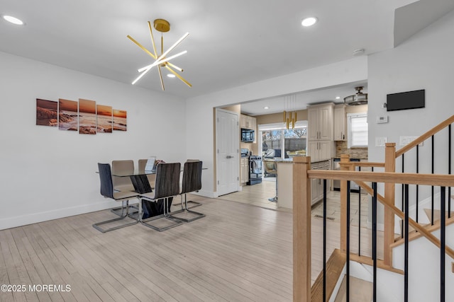 dining space featuring recessed lighting, a notable chandelier, light wood-style flooring, and baseboards