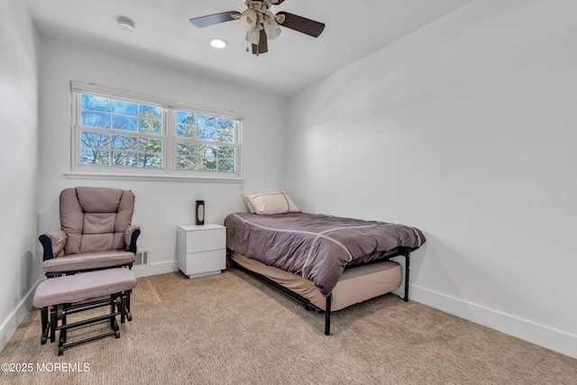 bedroom with visible vents, baseboards, light colored carpet, and ceiling fan