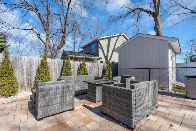 view of patio / terrace with a storage shed, an outbuilding, a fenced backyard, and an outdoor hangout area