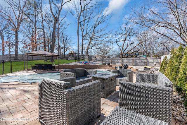 view of patio / terrace with a gazebo, an outdoor living space with a fire pit, and a fenced backyard