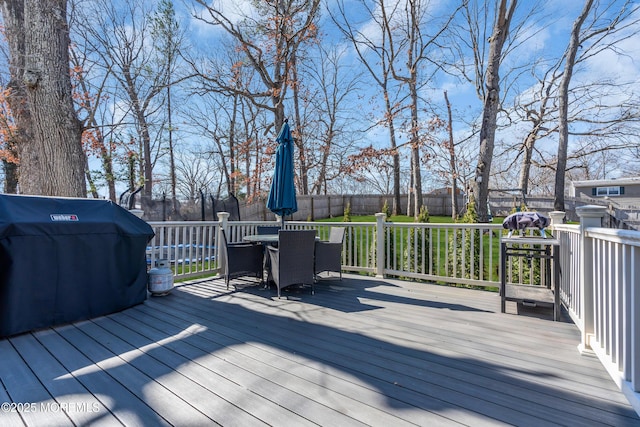 wooden terrace featuring grilling area, outdoor dining space, and fence