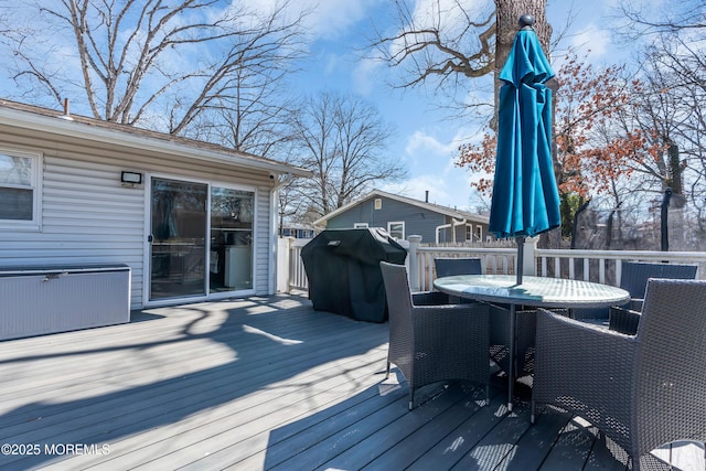 deck with outdoor dining area and a grill